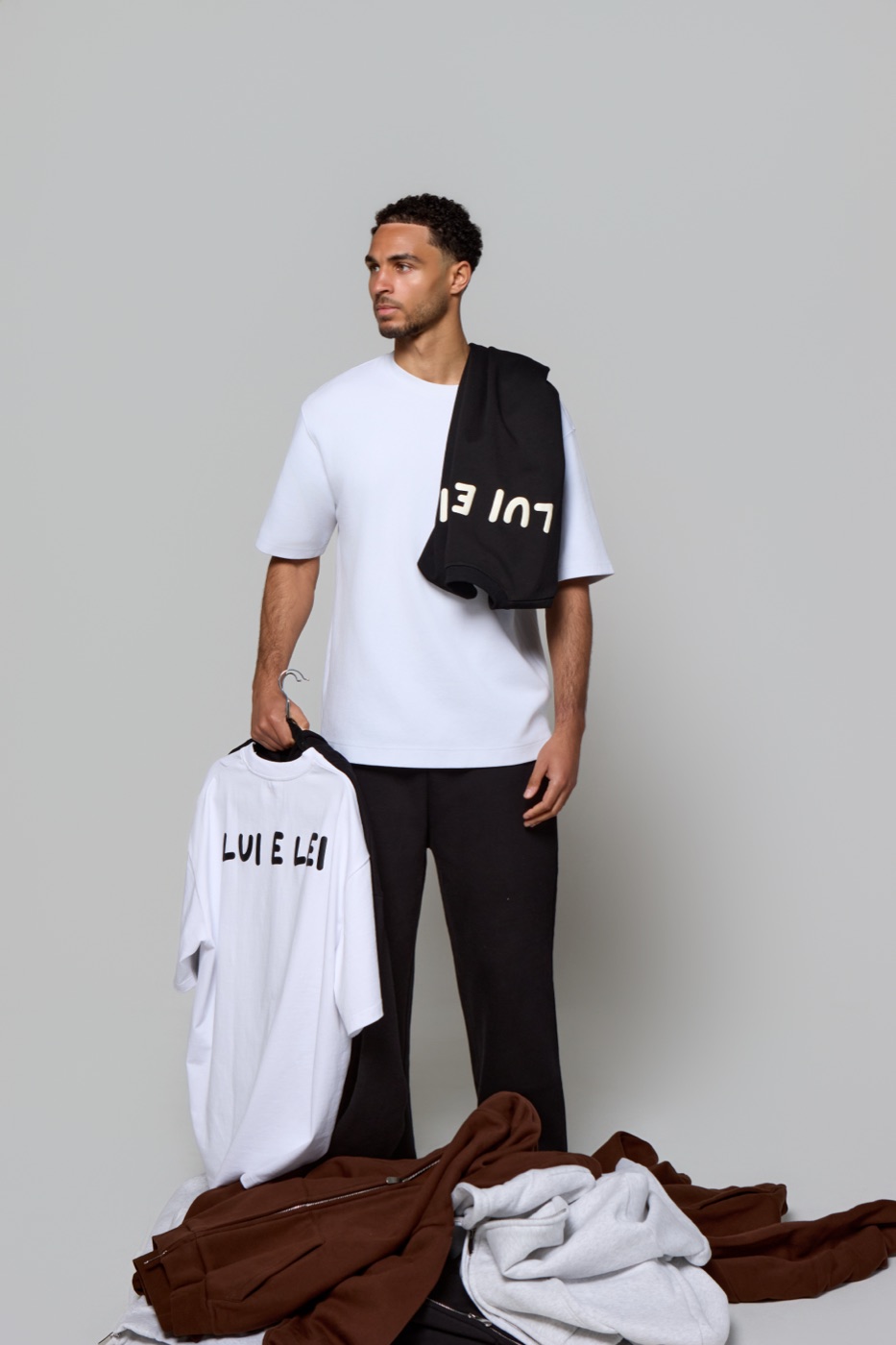 Kyle Jameson holding a Lui e Lei t-shirt